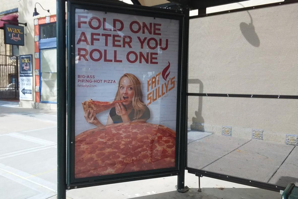 Bus Stop Poster Advertisement for Fat Sully's Showcasing a Girl Eating Pizza