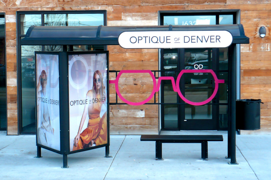 Bus Stop Enhanced Curbside Castle Advertisement for Optique of Denver Showcasing a Glasses Design